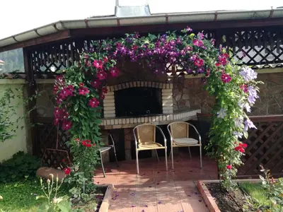 a pergola with a table and chairs and flowers at Guest House Benita in Devin