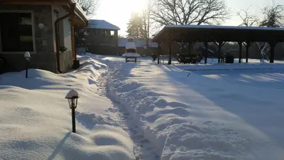 a snow covered yard with footprints in the snow at Mountain View Vacation Home in Balabanska
