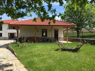 a house with two chairs in the yard at Mountain View Vacation Home in Balabanska