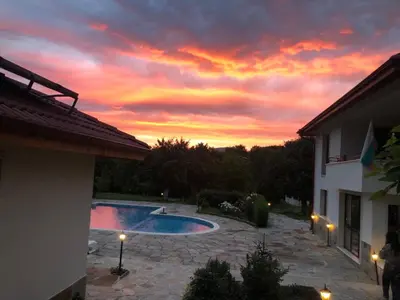 a sunset over a swimming pool at a house at Mountain View Vacation Home in Balabanska