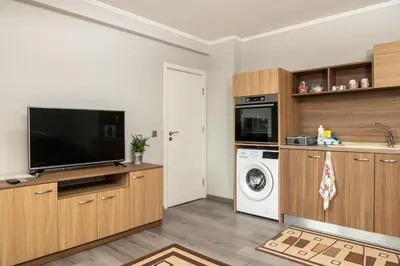 a living room with a tv and a washing machine at Panorama Apartment in Velingrad