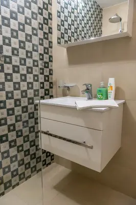 a bathroom with a white sink and a mirror at Panorama Apartment in Velingrad