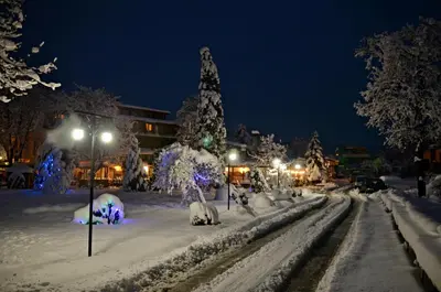 a city street covered in snow at night at Panorama Apartment in Velingrad