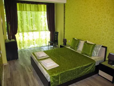 a green bedroom with a bed and a window at Apartments Vasil Levski in Plovdiv