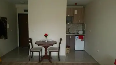 a kitchen with a table and chairs in a room at Park View Studios in Sandanski