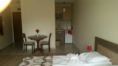 a bedroom with a bed and a table and a kitchen at Park View Studios in Sandanski