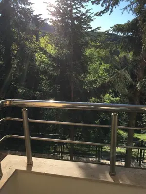 a railing on a bridge with trees in the background at Park View Studios in Sandanski