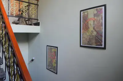two pictures hanging on a wall next to a staircase at Guest house Maison 21 in Plovdiv