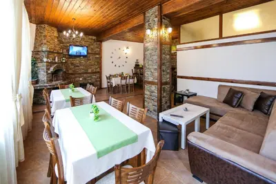 a dining room with a table and a couch at House of Time in Ognyanovo