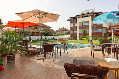 a patio with tables and chairs and a pool at White House in Ognyanovo