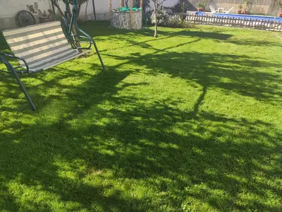 a park bench sitting in the grass in a yard at Guesthouse Argacho in Stob