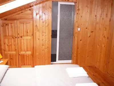 a bedroom with wooden walls and a bed and a window at Guesthouse Argacho in Stob