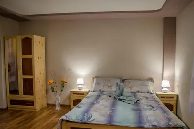 a bedroom with a bed with two night stands and two lamps at Guesthouse Juli in Sapareva Banya
