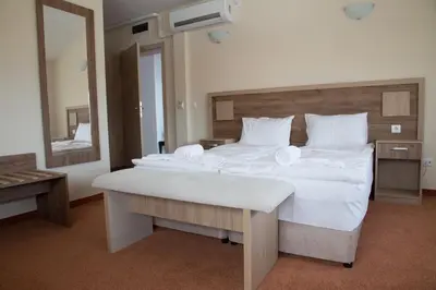 a large white bed in a room with a mirror at Sveti Nikola Family Hotel Sapareva Banya in Sapareva Banya