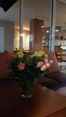 a vase filled with flowers sitting on a table at Family Hotel Kartala in Blagoevgrad