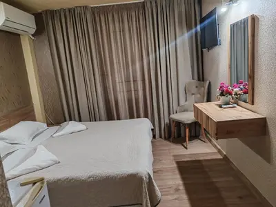 a hotel room with a bed and a table and a chair at Family Hotel Kartala in Blagoevgrad