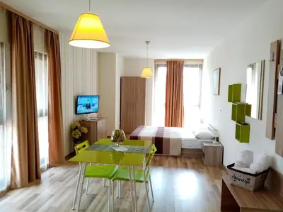 a living room with a dining table and a bedroom at Apart Hotel Rosen in Sofia