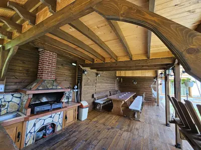 a large room with a table and a fireplace at Villa Hills - къща за гости с храна in Orlino