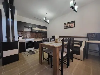 a kitchen and dining room with a table and chairs at Ваканционна къща ,,Родопски уют 
