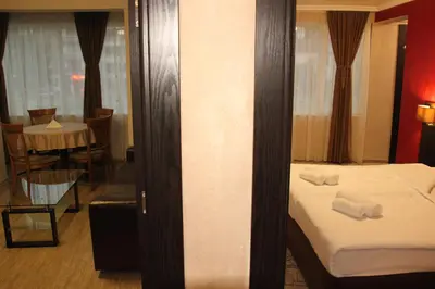 a hotel room with a bed and a mirror at Central Guest Rooms in Asenovgrad