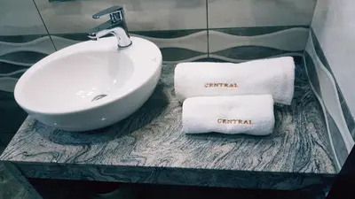 a bathroom with a sink and towels on a counter at Central Guest Rooms in Asenovgrad