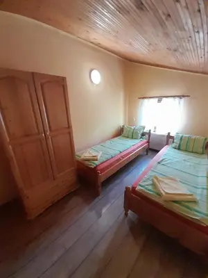 a room with two beds and a window in it at Guest House Lorian in Madzhare