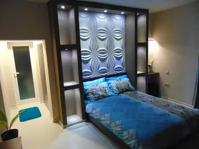 a bed in a room with a wall at Georgievi Guest House in Sapareva Banya