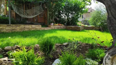 a yard with green grass and a hammock at Georgievi Guest House in Sapareva Banya