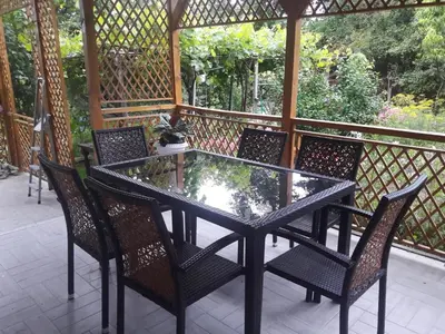 a glass table and chairs on a patio at Georgievi Guest House in Sapareva Banya