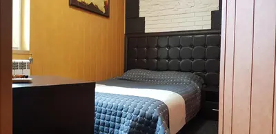 a bedroom with a bed with a black head board at Hotel Chamishki in Blagoevgrad