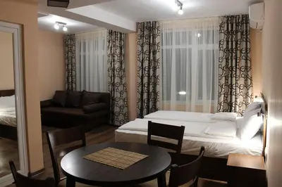 a room with a bed and a table and a couch at Center Guest House in Sapareva Banya