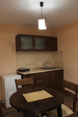 a kitchen with a table and a sink and a table and chairs at Center Guest House in Sapareva Banya