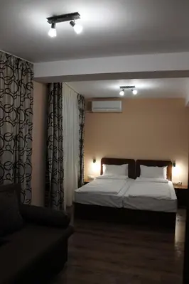 a bedroom with a bed and a couch in it at Center Guest House in Sapareva Banya