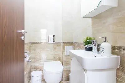 a bathroom with a white toilet and a sink at Domus Apartments Old Town with Garage in Plovdiv