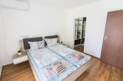 a bedroom with a large bed with blue and pink pillows at Domus Apartments Old Town with Garage in Plovdiv