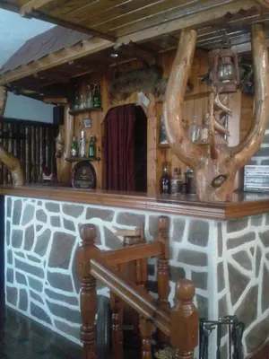 a bar with antlers on a stone wall at Tsvetkovi Guest House in Dobrinishte