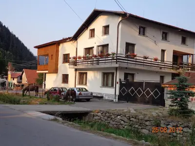 a white house with a car parked in front of it at Family Hotel Ecorelax in Madzhare