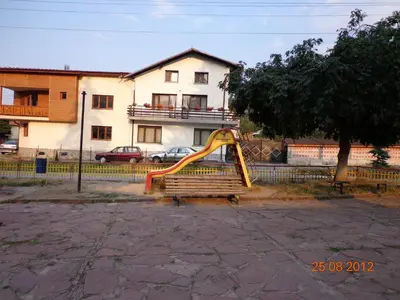 a playground with a slide in front of a house at Family Hotel Ecorelax in Madzhare