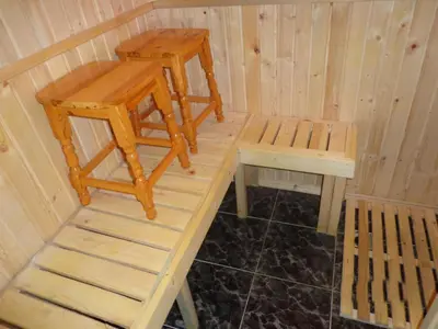 a wooden sauna with a bench and a stool at Family Hotel Ecorelax in Madzhare