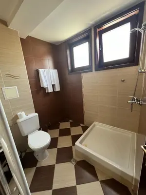a bathroom with a toilet and a bath tub at Panorama Guest House in Smolyan