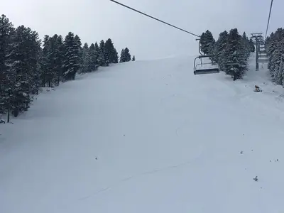 a snow covered ski slope with a ski lift at Entire Private Apartment in Pirin Golf & Country Club in Bansko