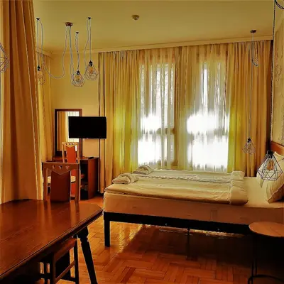 a bedroom with a large bed and a window at СКЕРЦО SkerZZo Guest House in Plovdiv