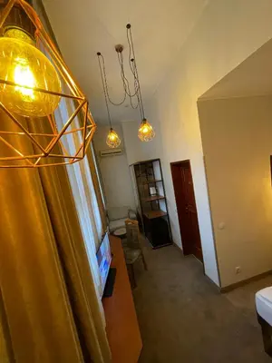 a living room with a yellow curtain and a window at СКЕРЦО SkerZZo Guest House in Plovdiv