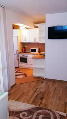 a kitchen with white cabinets and a white refrigerator at United Apartments in Sandanski