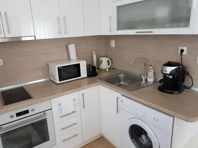 a kitchen with a sink and a microwave at United Apartments in Sandanski