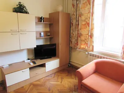 a living room with a desk with a tv and a chair at Asen 36 Apartment in Sofia