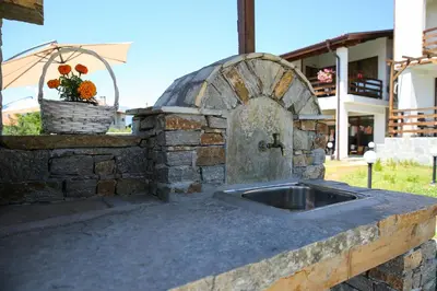 a stone kitchen with a sink and a basket of flowers at Guest House Ognyanovo in Ognyanovo