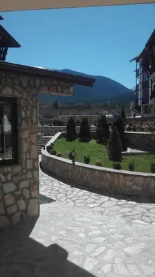 a stone building with a stone walkway with a garden at Mountain Top Mina in Bansko