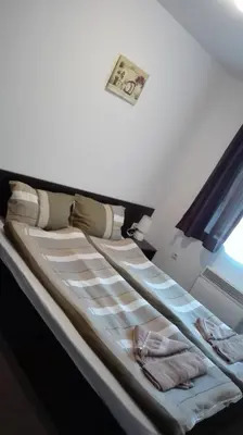 a bed in a room next to a window at Mountain Top Mina in Bansko