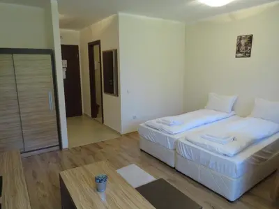a hotel room with two beds and a table at Rivendell Apartments Borovets Gardens complex in Borovets